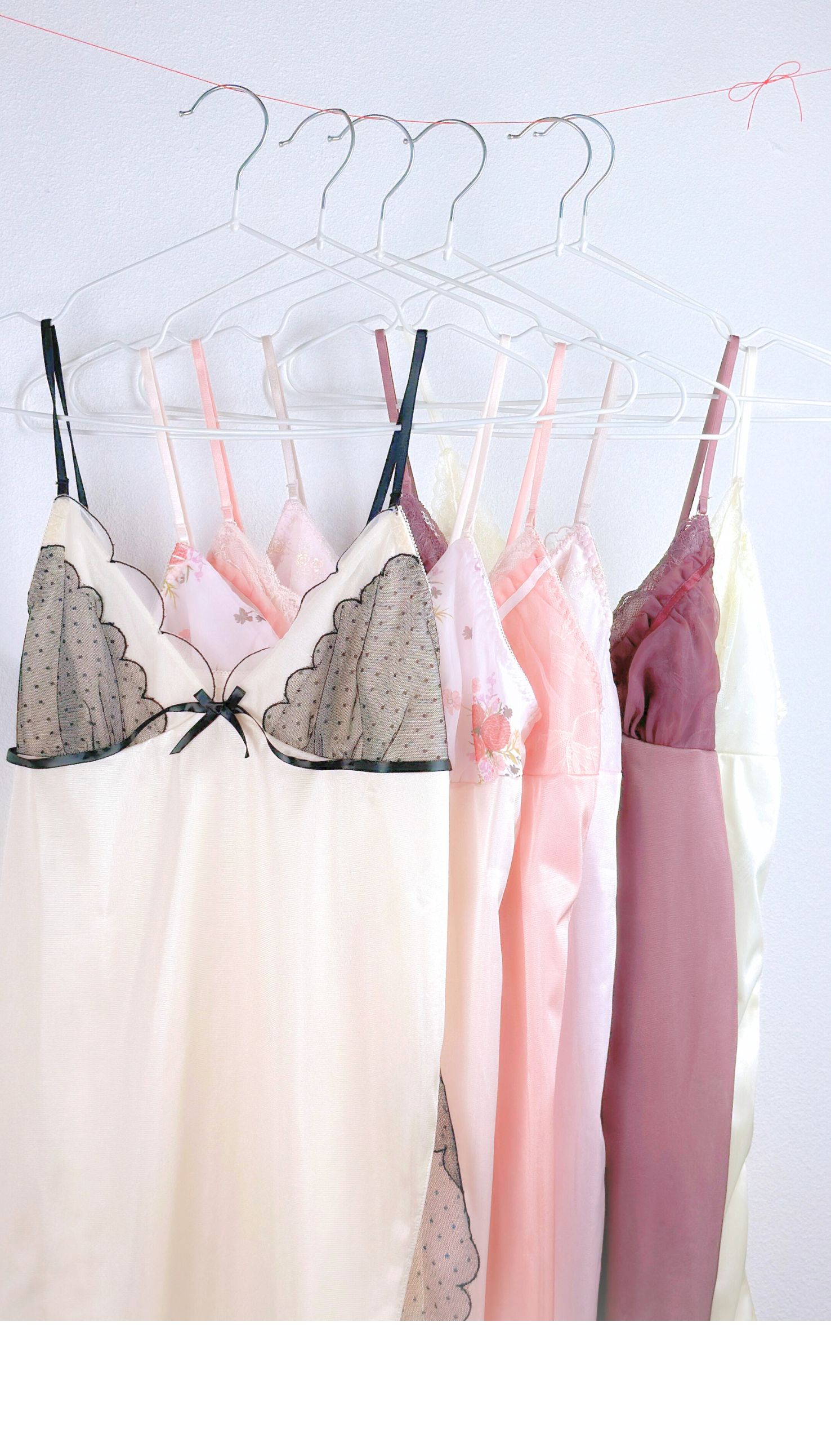 Silk lingerie on hangers against a white background